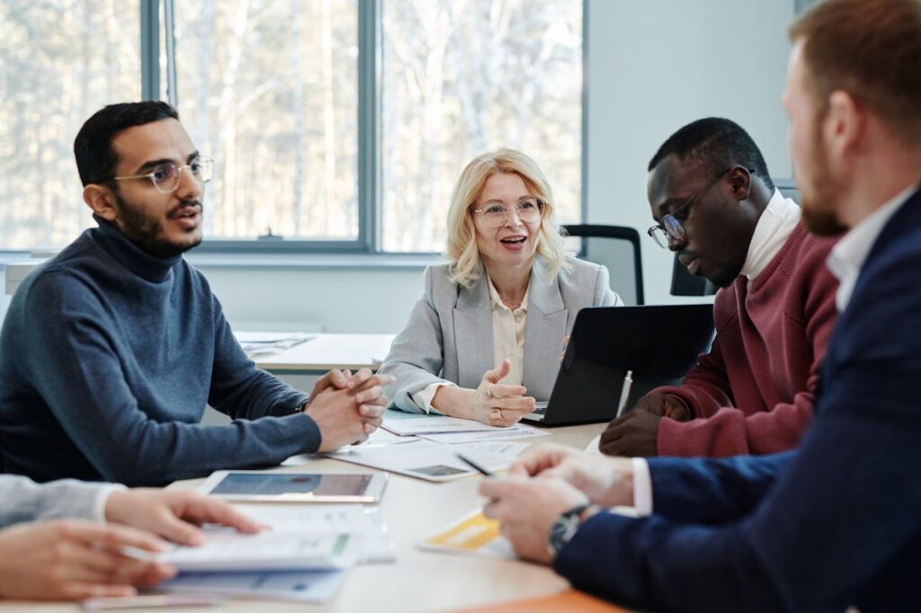 Group of professionals in a meeting discussing teamwork in an office.