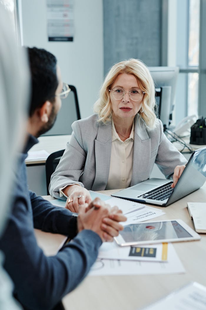 Caucasian woman leading a business meeting in a modern office setting.